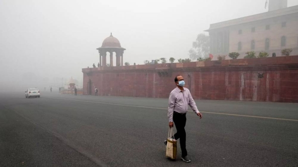 A pedestrian wears a face mask amidst a thick layer of smog in New Delhi, India