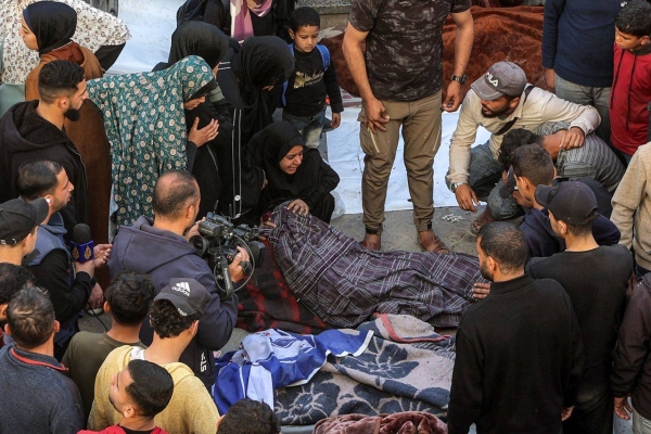 Women mourn near the bodies of victims killed in Israeli bombardment as they lie wrapped in blankets at the Ahli Arab hospital, in Gaza on Tuesday.