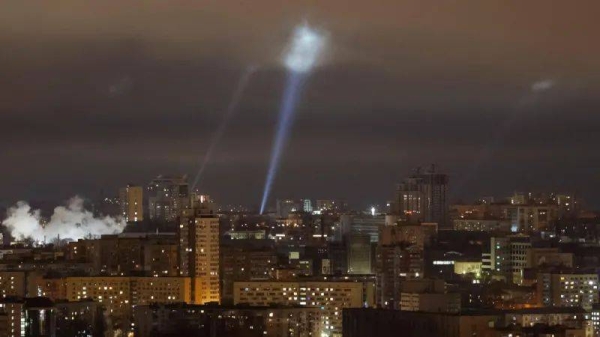 Ukrainian service personnel use searchlights as they search for drones in the sky over Kyiv on Tuesday night