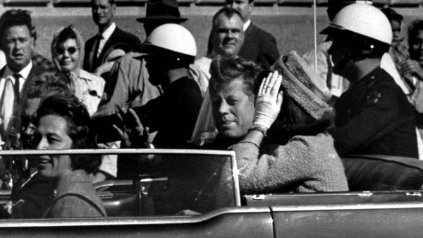 President John F. Kennedy waves from his car in a motorcade approximately one minute before he was shot on November 22, 1963, in Dallas