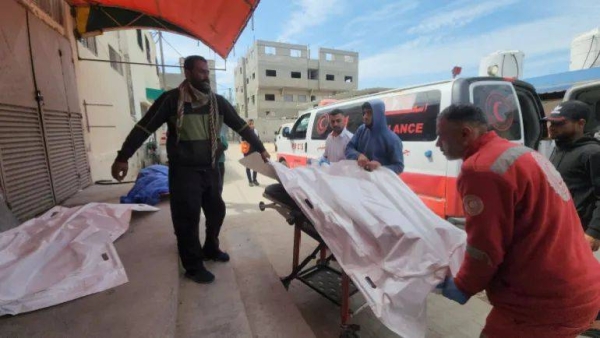 Mourners and a paramedic move the body of a Palestinian killed in an Israeli strike, according to medics, at Al-Aqsa Martyrs Hospital in Deir el-Balah, Gaza, on March 17, 2025 [