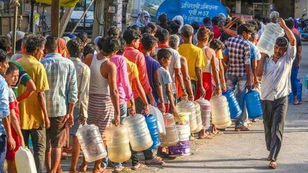 People queue to fill water from a tanker during a heat wave at Chilla Village on June 13, 2024 in New Delhi, India