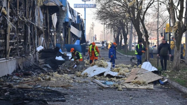 Municipal workers clean up after Russian drones hit shops during the night attack in Odesa, Ukraine, Friday, March 21, 2025