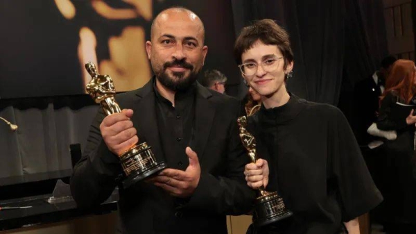 Hamdan Ballal poses with Rachel Szor after they won Best Documentary Feature Film for No Other Land at the Oscars