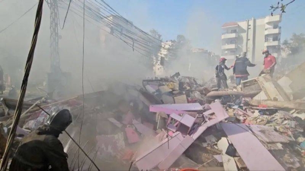 Recovery work in Dahieh, showing a large pile of debris, with a lot of pink crushed-up furniture
