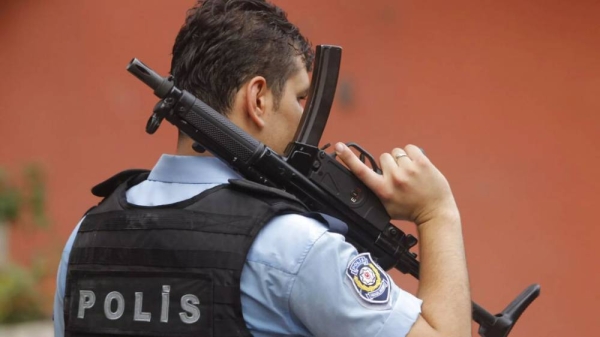 An armed Turkish police officer secures a road leading to the U.S. Consulate building in Istanbul