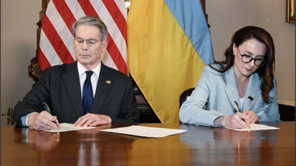 US Treasury Secretary Scott Bessant (l) and Ukraine's First Deputy Prime Minister Yulia Svyrydenko (r) sign the natural resources deal