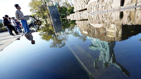 The Statue of Peace is reflected on water fountain at the Peace Park in Nagasaki, 16 November, 2019