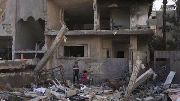 Palestinians inspect a house destroyed by an Israeli air strike in Deir al-Balah, 21 May, 2025