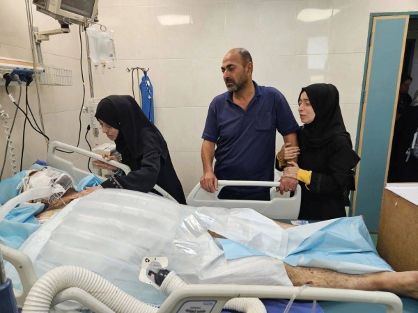 Palestinian doctor Alaa al-Najjar visits her injured husband Hamdi in the intensive care unit at Nasser Hospital in Khan Younis, Gaza, after an Israeli airstrike hit their home