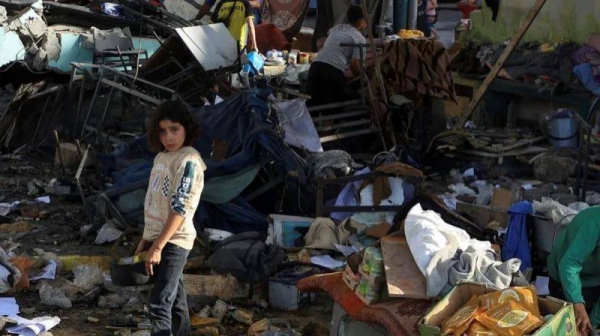 A girl stands in the ruins of the school building in Gaza City that was hit by an air strike