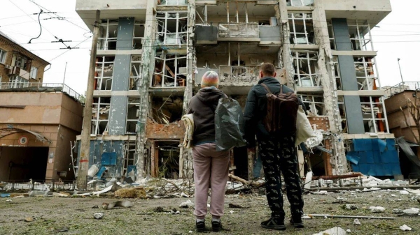 Residents look at a Kyiv apartment building that was damaged in a Russian drone strike on May 25, 2025