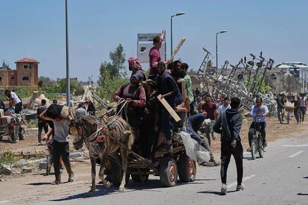 Palestinians carry humanitarian aid packages in Khan Younis, 29 May