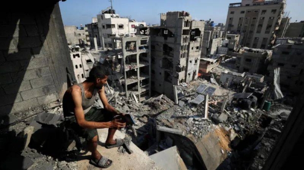 A Palestinian man looks at buildings destroyed by Israeli strikes in al-Shati refugee camp, northern Gaza