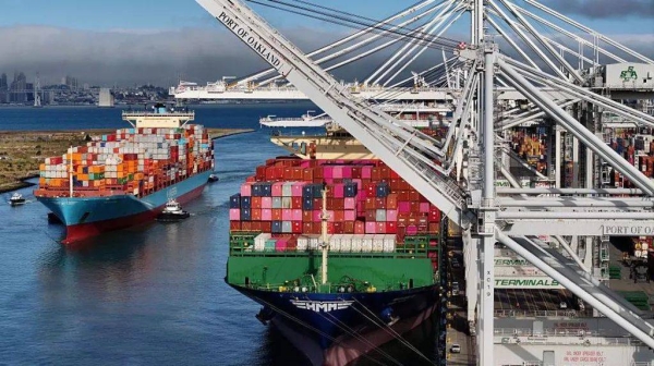 Two ships with multi-coloured containers at the Port of Oakland, California.
