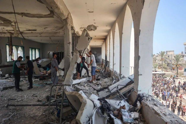 Palestinians clamber over the rubble, after Israel forces attacked the Khadija school, central Gaza, on July 27, 2024