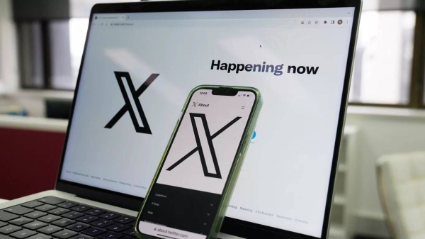 The opening page of X is displayed on a computer and phone in Sydney on Oct. 16, 2023