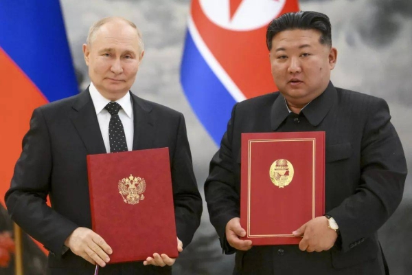 Russian President Vladimir Putin, left, and North Korea's leader Kim Jong Un pose for a photo during a signing ceremony of the new partnership in Pyongyang, North Korea