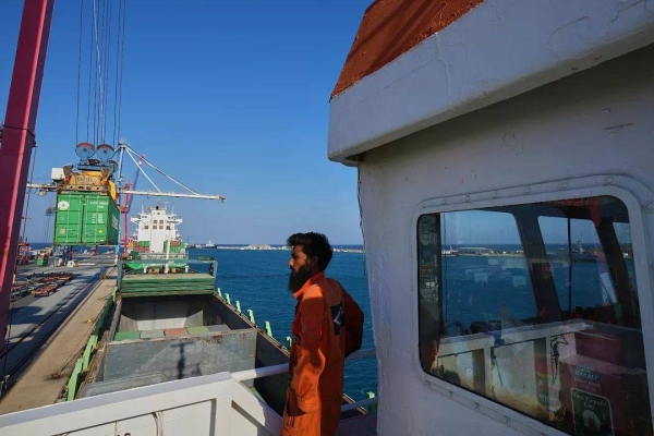 Jalal Uddin, electrical and technology officer aboard a Panamanian-flagged ship watches as containers filled with aid are loaded at the port in Limassol, 18 August, 2025