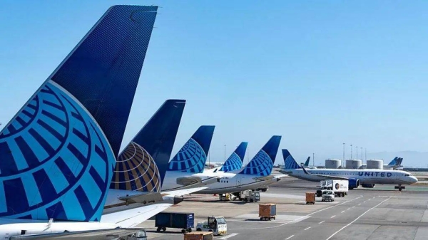 A row of five United Airlines jets parked at San Francisco International Airport. The photo is a tight shot of the aircraft's tailfins, which depicts the company's globe logo