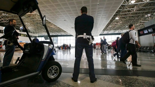 Police officers patrol the check in area of the Milan's Malpensa international airport, in Busto Arsizio, Italy, Tuesday, March 22, 2016