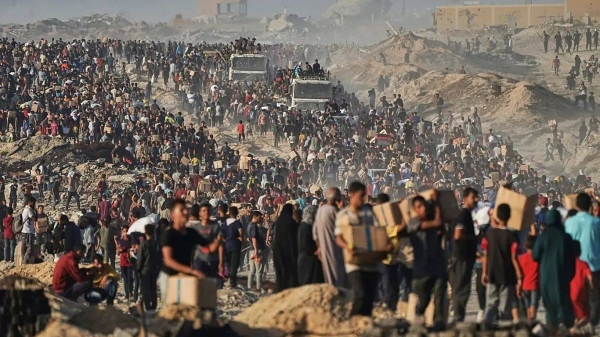 Palestinians carry sacks and boxes of food and humanitarian aid unloaded from a World Food Programme convoy in northern Gaza, 16 June, 2025