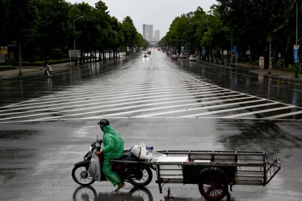 A man rides a motorbike on a road before Typhoon Kajiki makes landfall in Vietnam, in Nghe An province on August 25, 2025