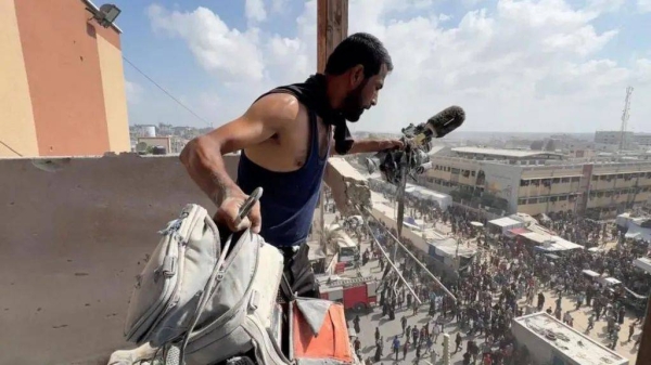 A man holds the equipment of journalist Hussam al-Masri who was filming a live TV feed from Nasser hospital