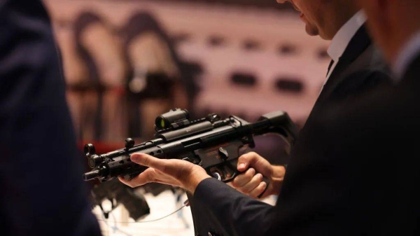 A visitor tries a range of submachine guns at the DSEI 2023 exhibition in London