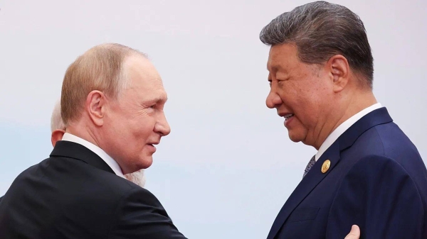 Russian President Vladimir Putin talks with Chinese President Xi Jinping during a family photo session at the SCO summit in Tianjin, 1 September 2025