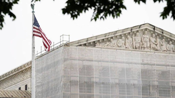 The exterior of the US Supreme Court with an American flag in foreground