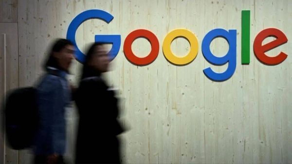 People walk next to a Google logo during a trade fair in Hannover Messe