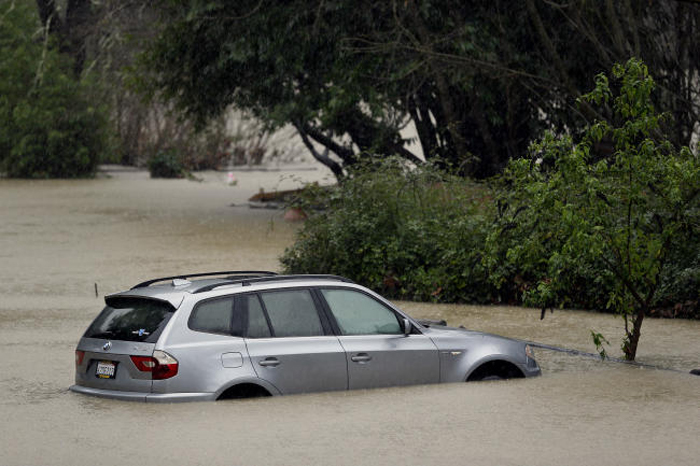 A car is submerged as the Russian River floods Johnson's Beach in Guerneville, California, on Tuesday. — AP