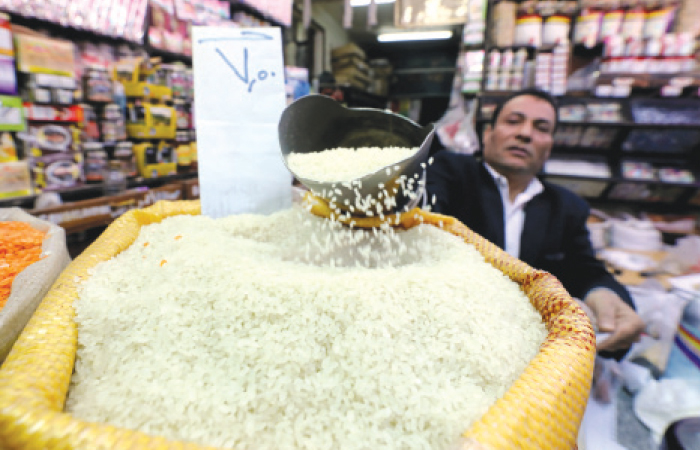 An Egyptian seller shows consumer goods as rice, at a vegetable market in Cairo