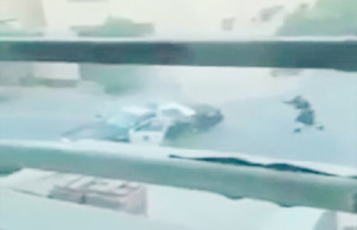 This screenshot from a video footage shows a Saudi security officer aiming his gun at one of the terrorists as the other runs toward a policeman’s car during a shootout in Riyadh on Saturday.