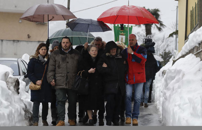 Massimiliano Giancaterino, second from left, the brother of Alessandro, one of the victims of the avalanche which struck the hotel Rigopiano, walks with his relatives prior to the start of the funeral service in Farindola, central Italy, on Tuesday. — AP