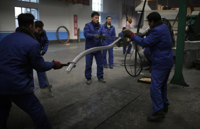 North Korean factory workers at the Pyongyang 326 Electric Wire Factory pull on an aluminum rod, in Pyongyang, North Korea, on Tuesday. — AP