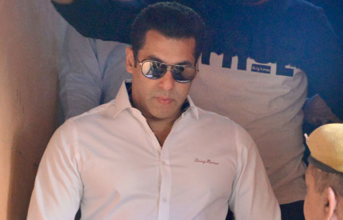 Indian Bollywood actor Salman Khan walks with officials as he leaves after a court appearance in Jodhpur on Wednesday. - AP