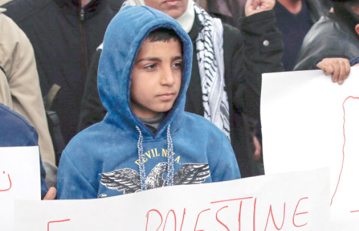 Palestinian children carry placards during a demonstration against proposed plans by President-elect Donald Trump to move the US embassy in Israel to Jerusalem, in the village of Kfar Qaddum, near Nablus, in the occupied West Bank. — AFP