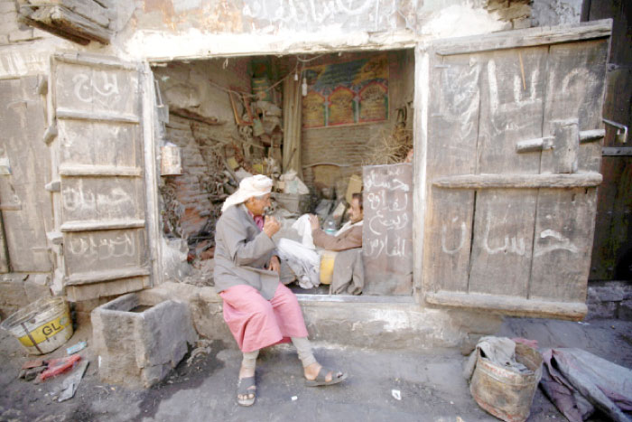A man talks to another while sitting outside a shop at the old market in the historic city of Sanaa. — Reuters