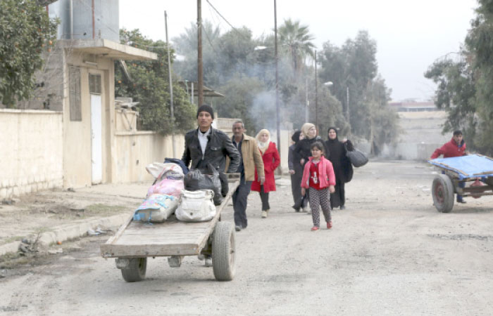 Civilians return to their neighborhood recently liberated from Daesh militants in the eastern side of Mosul. — AP