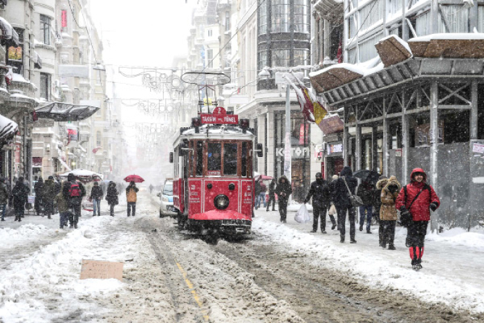 People walk on the Istiklal avenue during snowfalls in Istanbul on Saturday.  A heavy snowstorm paralyzed life in Istanbul with hundreds of flights cancelled and the Bosphorus closed to shipping traffic. The snowstorm dumped almost 40 centimeters (16 inches) of snow in parts of the Turkish metropolis overnight, causing havoc on roads as travelers sought to leave the city for the weekend getaway. — AFP