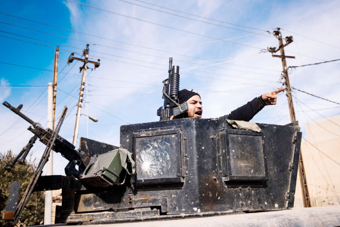 A member of the Iraqi special forces Counter Terrorism Service (CTS) shouts during a patrol in Mosul’s Al-Jazair neighborhood as he look for Daesh (the so-called IS) group fighters, during an ongoing military operation against the militants. — AFP