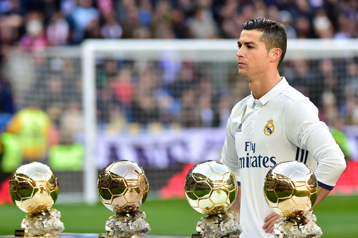 Real Madrid's forward Cristiano Ronaldo poses with his four Ballon d'Or France Football trophies before the Spanish league football match against Granada FC at the Santiago Bernabeu Stadium in Madrid Saturday. — AFP