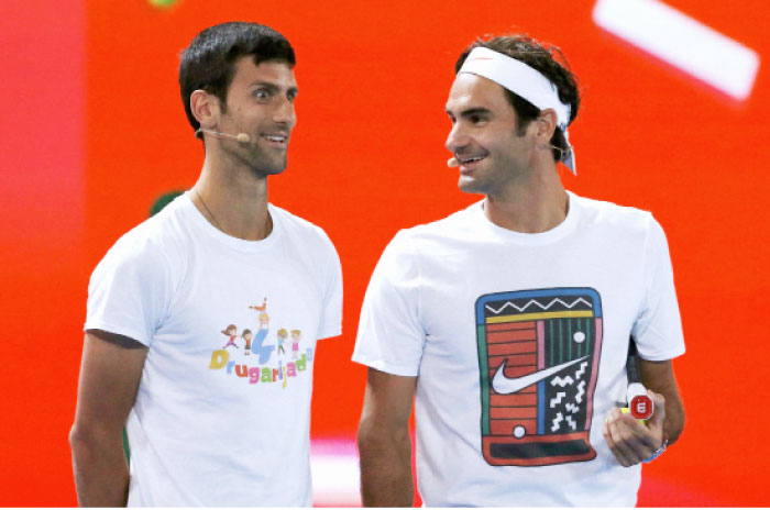 Switzerland’s Roger Federer and Serbia’s Novak Djokovic react during a promotional event ahead of the Australian Open tennis tournament in Melbourne Saturday. - Reuters