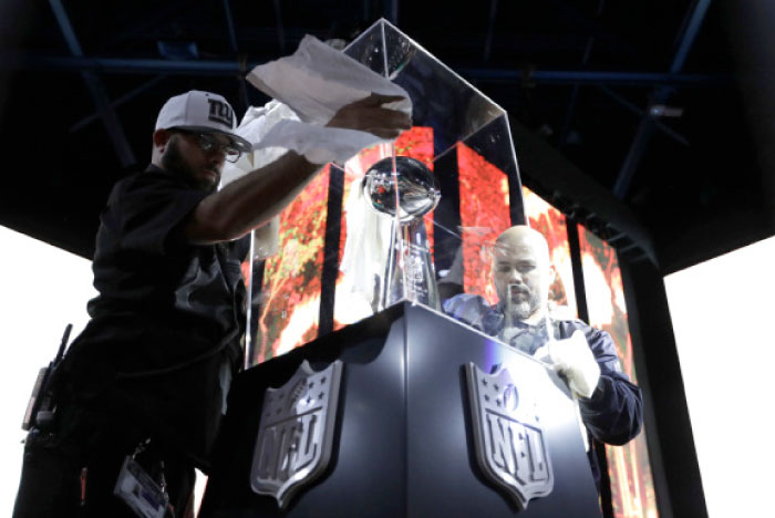 Workers prepare the Vince Lombardi Trophy display at the NFL Experience Saturday in Houston. The New England Patriots will play the Atlanta Falcons in Super Bowl LI Sunday, Feb. 5, at NRG Stadium in Houston. — AP