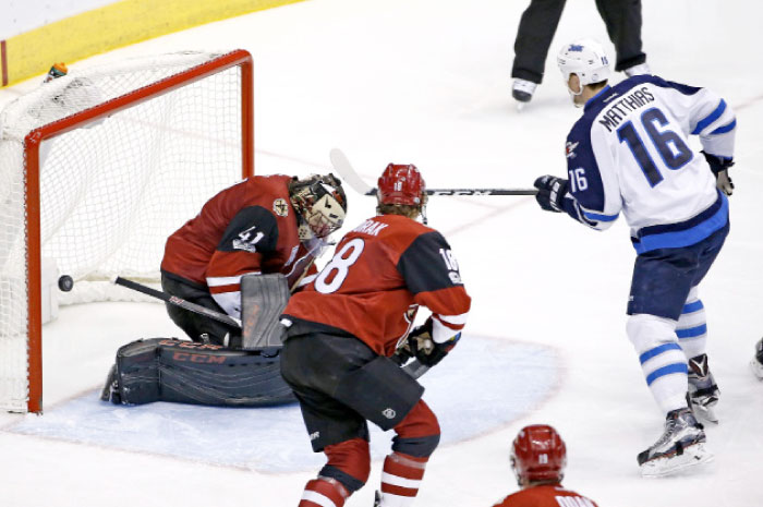 Arizona Coyotes’ goalie Mike Smith (L) gives up a goal to Winnipeg Jets’ defenseman Mark Stuart as Jets’ center Shawn Matthias (No. 16) and Coyotes’ center Christian Dvorak (No. 18) watch during their NHL game in Glendale, Arizona, Friday. - AP