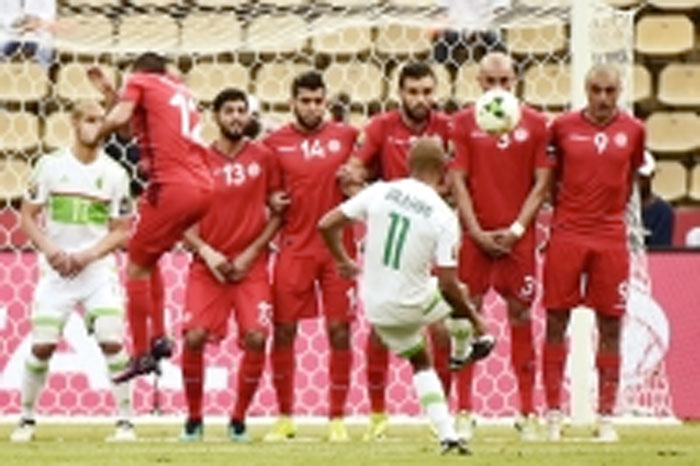 Tunisia’s players prepare to block a free kick by Algeria’s midfielder Yacine Brahimi during their Africa Cup of Nations match in Franceville Thursday. - AFP