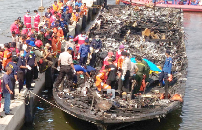 Rescuers search the charred passenger boat which was ferrying around 200 people off the coast of Jakarta to Tidung island, a tourist destination 50 km from the capital when a fire started on Sunday. — AFP