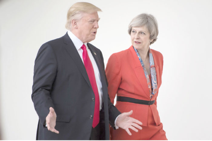 US President Donald Trump and British Prime Minister Theresa May walk at the White House in Washington, D.C., on Friday. — AFP